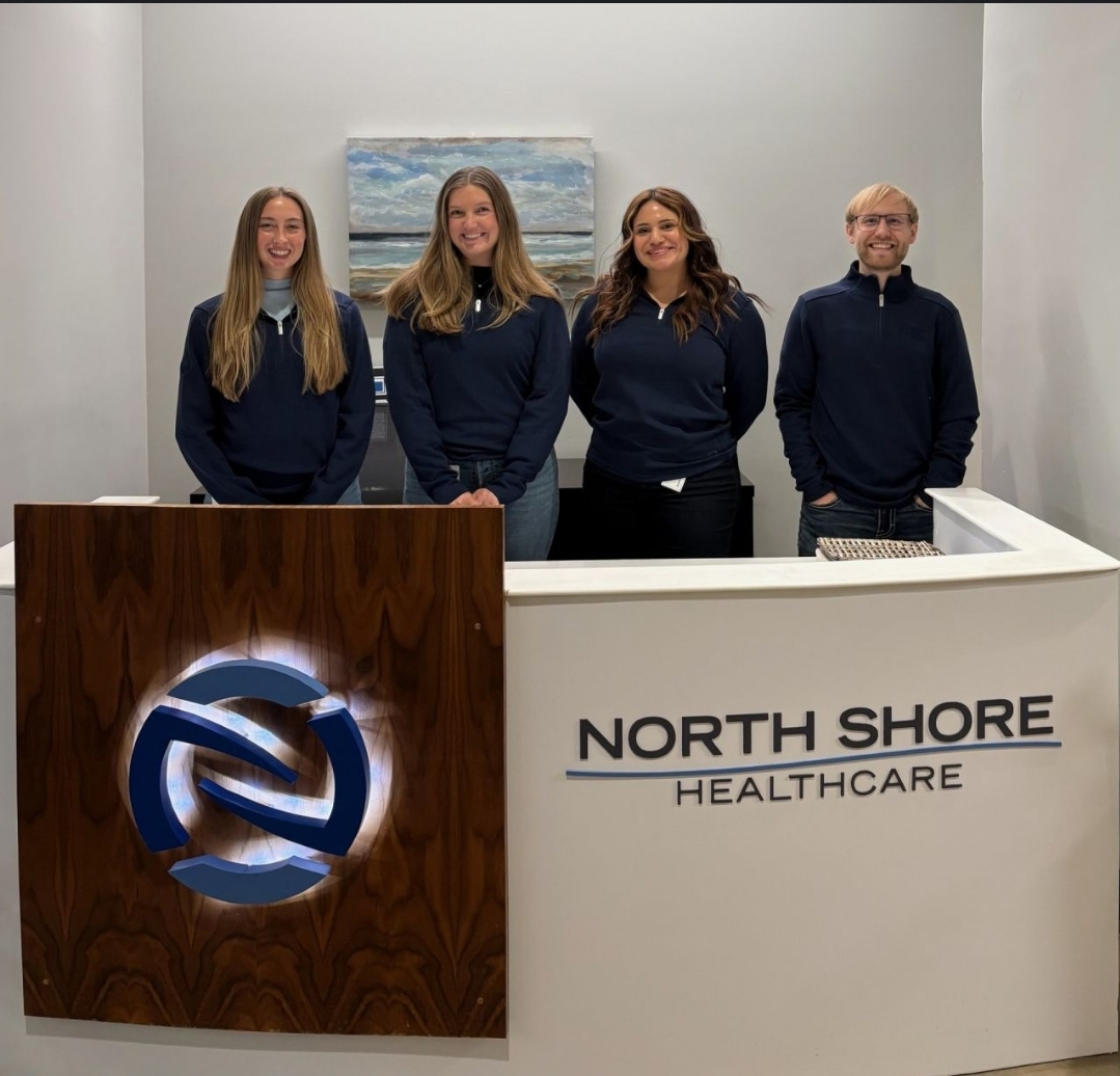 Carson Motowski with the North Shore Health team at the reception desk